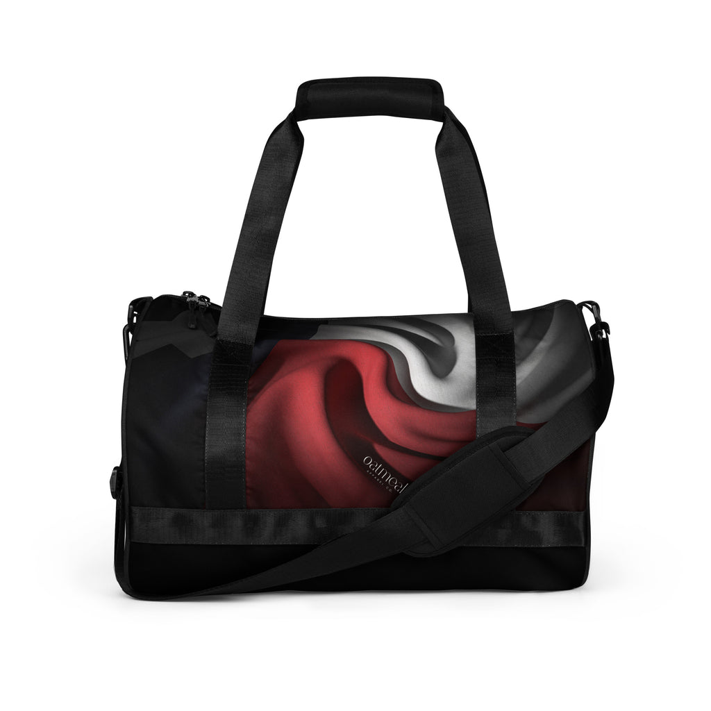 Black duffel bag with a red and gray custom abstract design on a white background at Oatmeal Apparel Co.