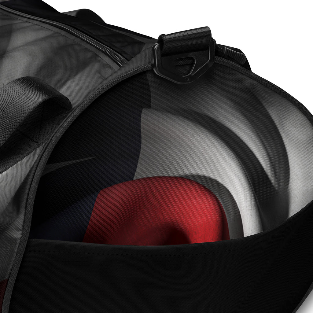 Close-up of a black duffel bag with a red, gray, and blue custom design at Oatmeal Apparel Co.