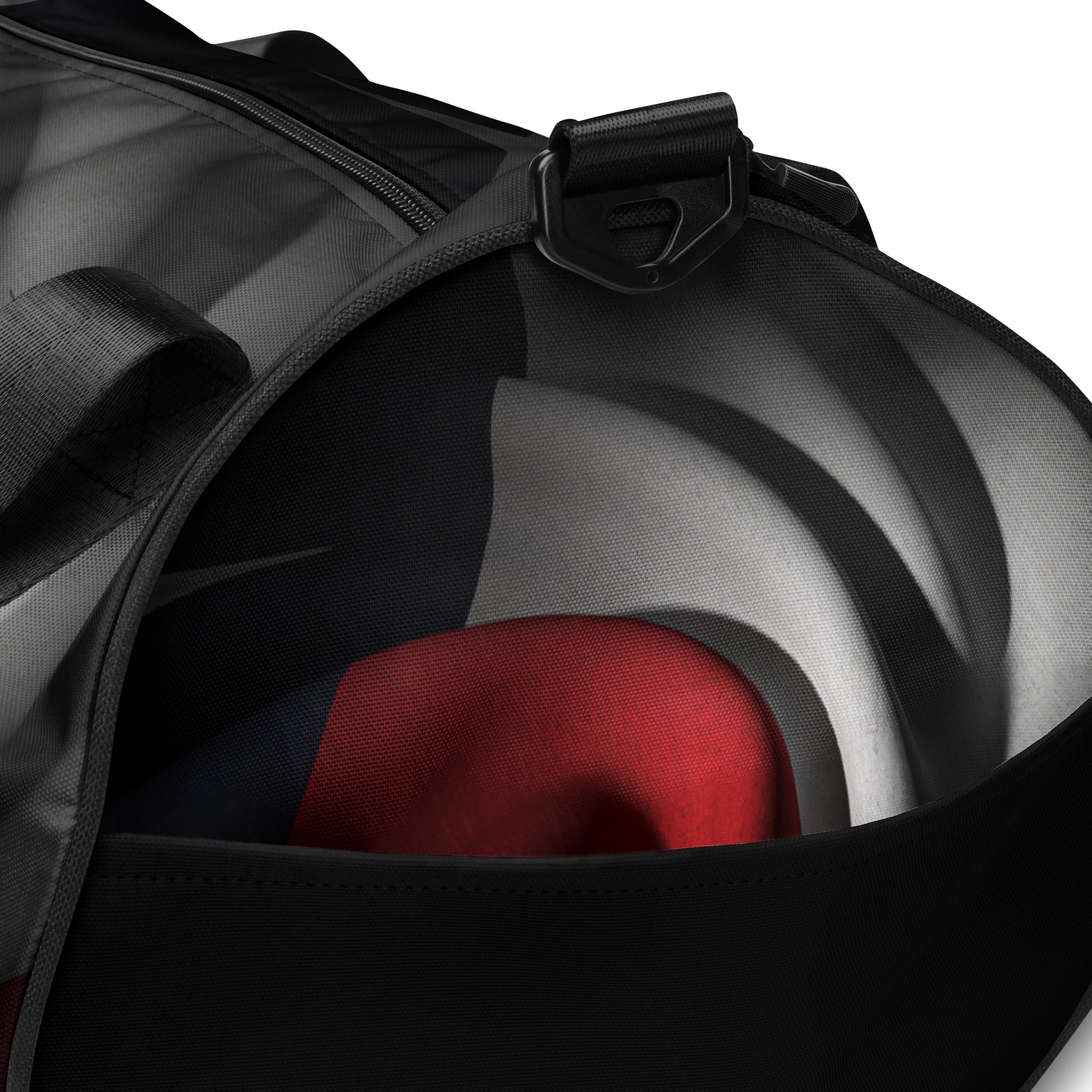 Close-up of a black duffel bag with a red, gray, and blue custom design at Oatmeal Apparel Co.