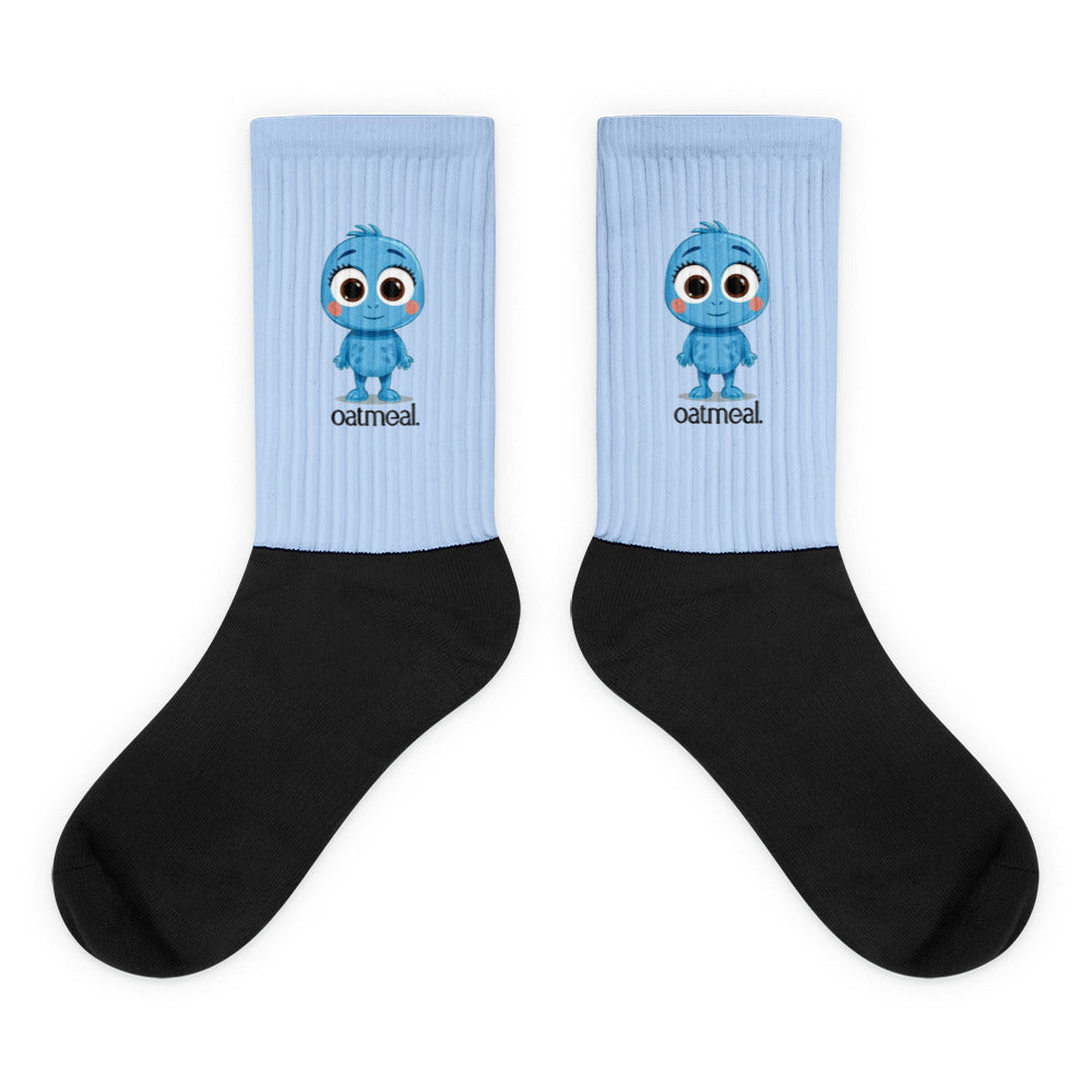 Pair of socks with a Oatmeal cartoon character and 'oatmeal' branding on a light blue background at Oatmeal Apparel Co.