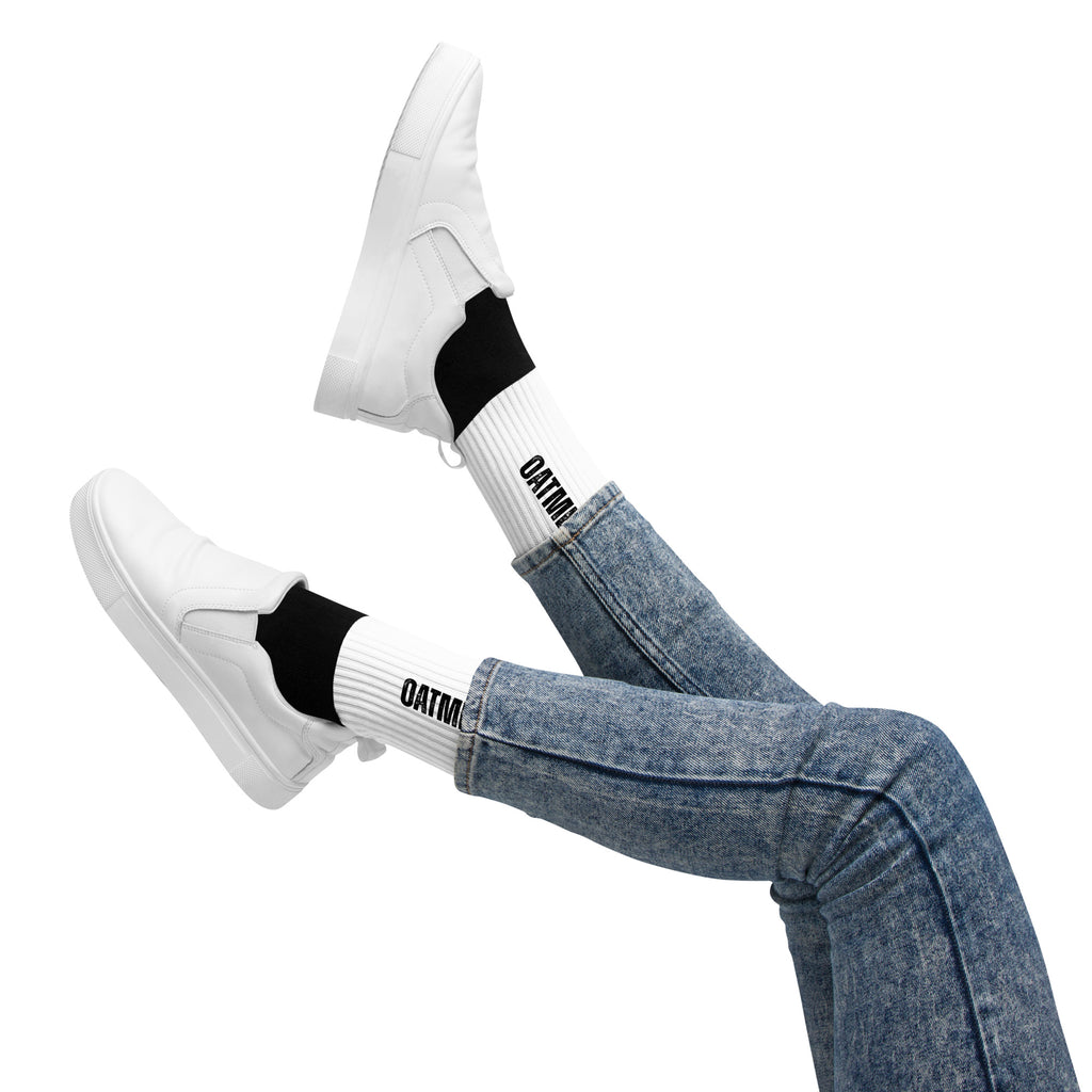 White sneakers, black socks with 'Oatmeal' branding, and blue jeans on a white background at Oatmeal Apparel Co.