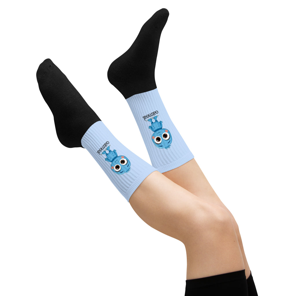 Black socks with light blue cuffs featuring Oatmeal cartoon characters on a white background at Oatmeal Apparel Co.