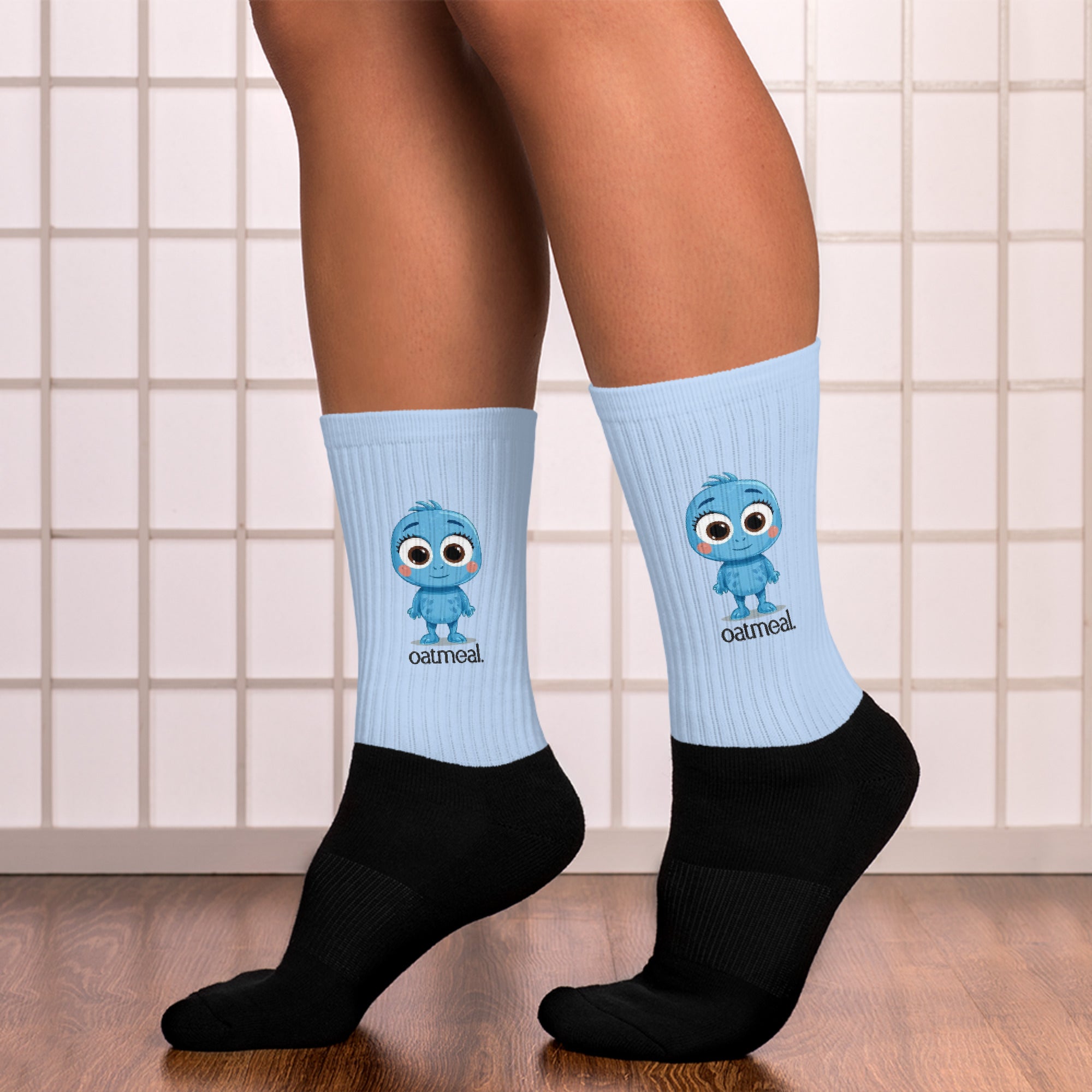 Person wearing light blue socks with Oatmeal cartoon character design and black socks on a tiled floor at Oatmeal Apparel Co.