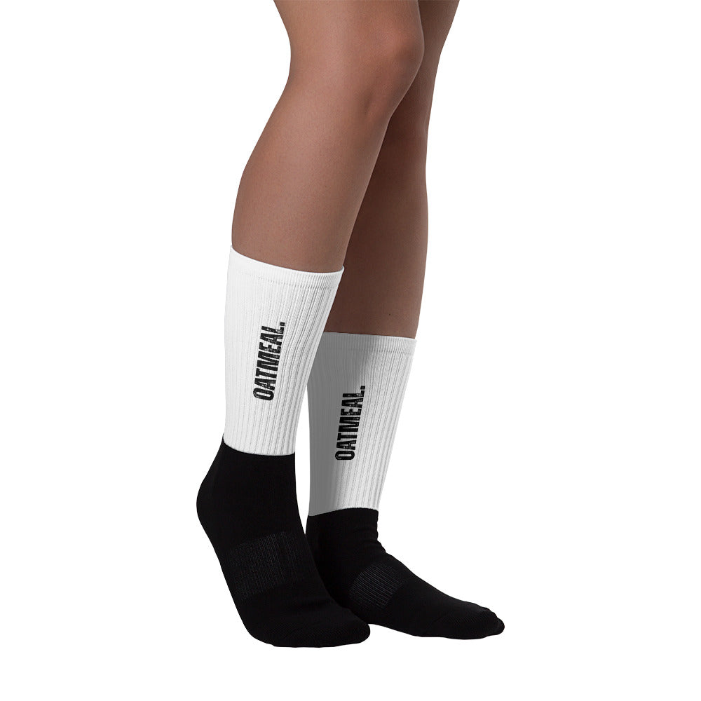 White and black socks with 'Oatmeal' branding on a white background at Oatmeal Apparel Co.
