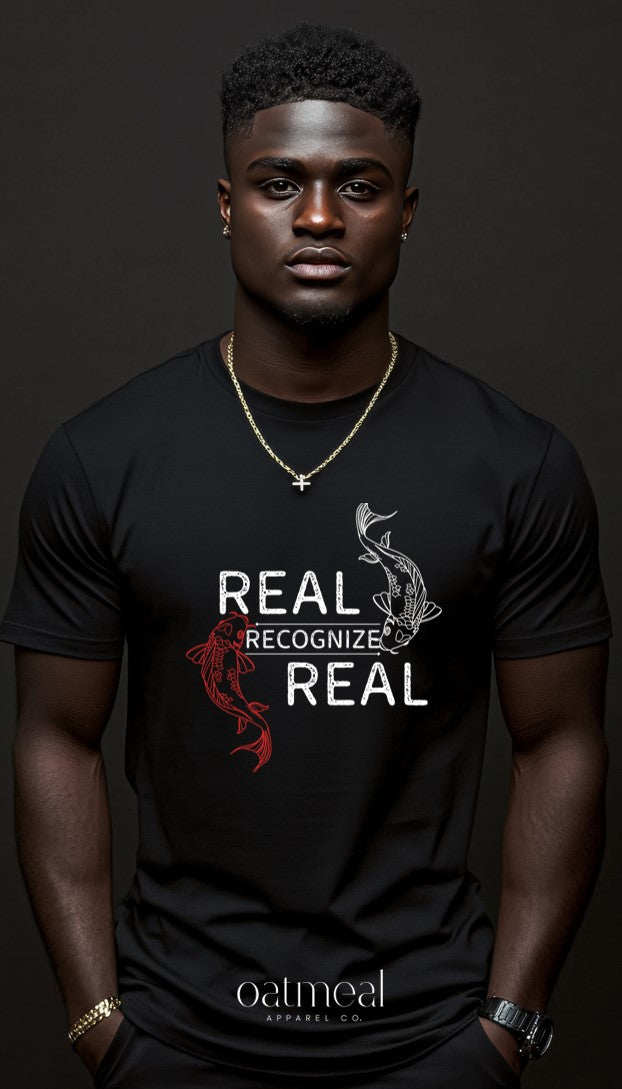 Man wearing a black t-shirt with 'Real Recognize Real' custom design and Oatmeal Apparel Co. branding.