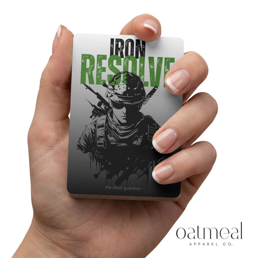 Hand holding a card with 'Iron Resolve' design and 'Oatmeal Apparel Co.' branding.