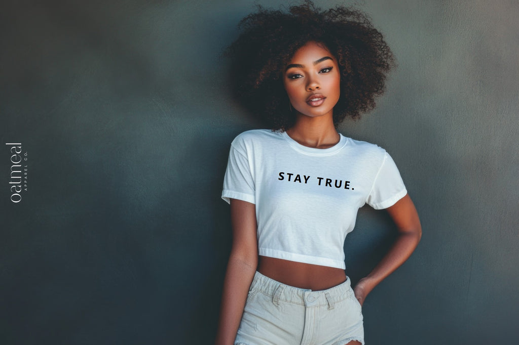 Person wearing a white t-shirt with 'STAY TRUE.' text against a dark background with 'oatmeal apparel co.' branding.