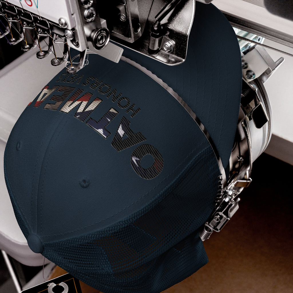 Navy blue cap with embroidered text on an embroidery machine, hat exclusively available at Oatmeal Apparel Co.