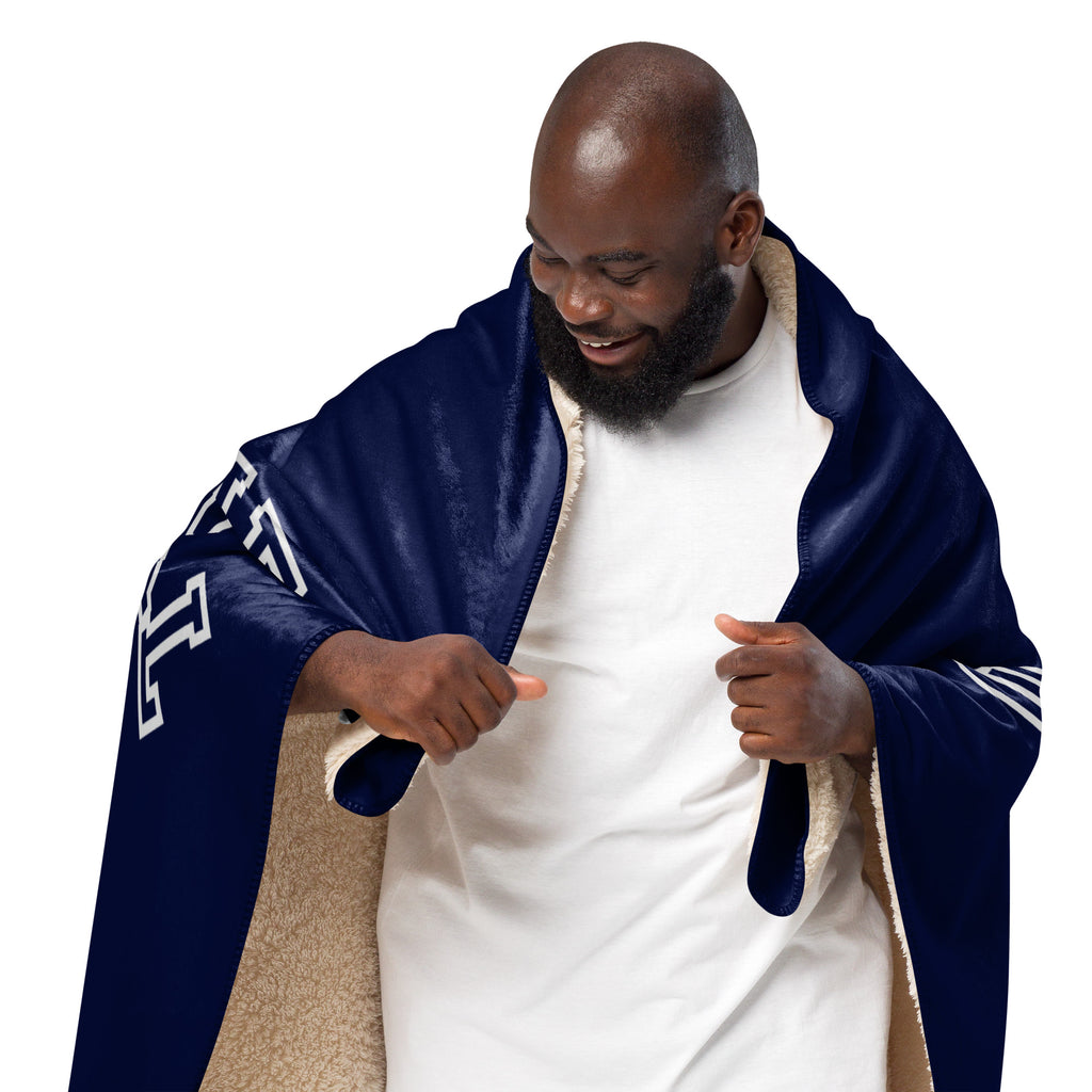 Man wrapped in a blue 'OATMEAL SPORTS' edition blanket at Oatmeal Apparel Co.