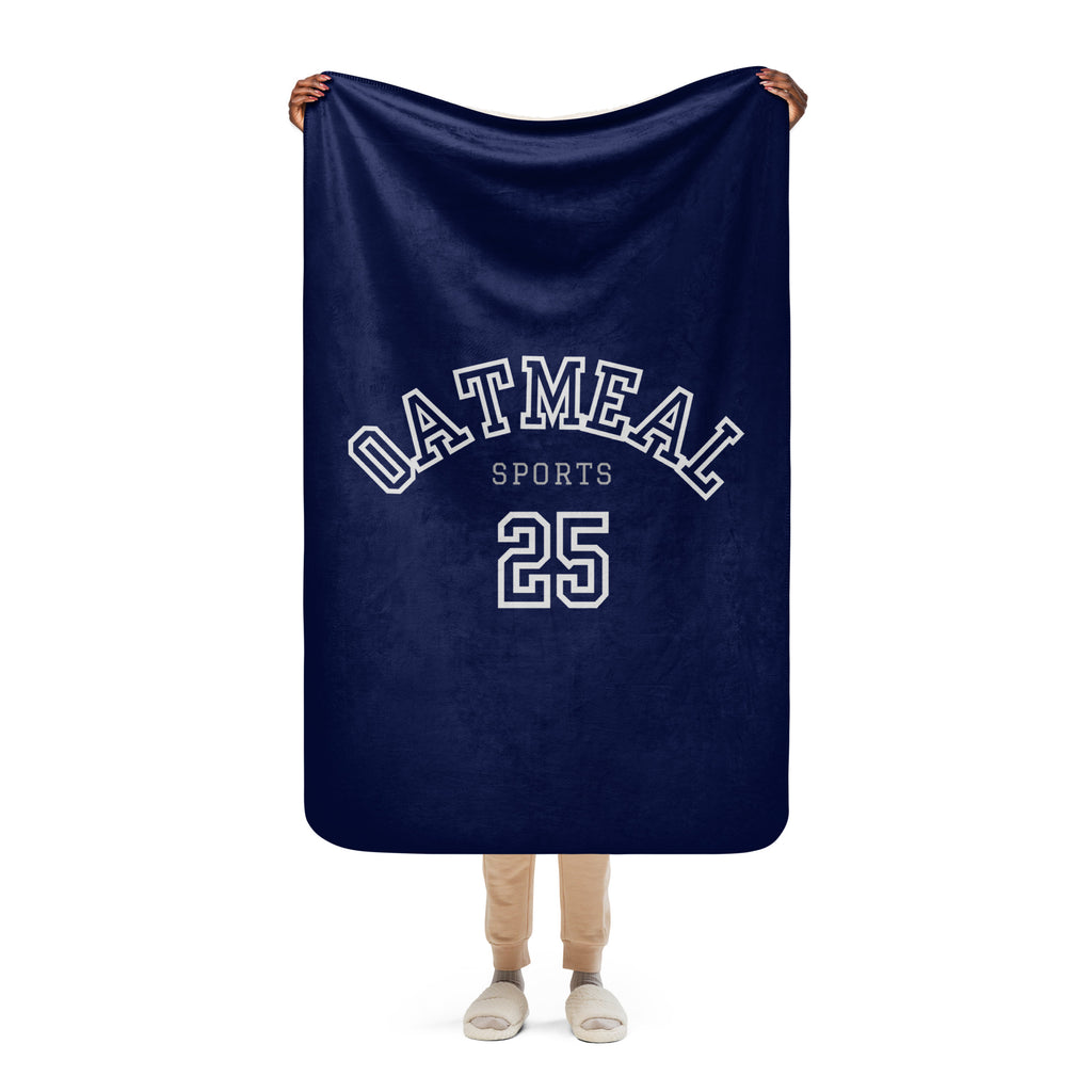 Navy blue blanket with 'Oatmeal Sports' and number '25' held by a person on a white background at Oatmeal Apparel Co.