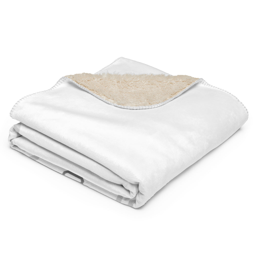 Folded white blanket with beige lining on a white background available at Oatmeal Apparel Co.