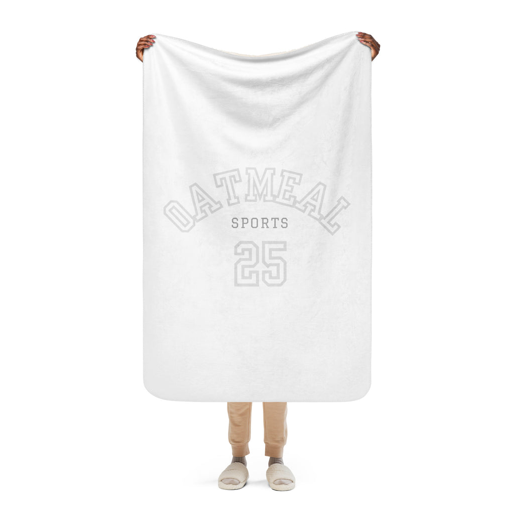 Person holding a white blanket with 'Oatmeal Sports 25' text on a white background exclusively from Oatmeal Apparel Co.