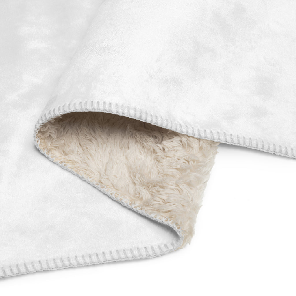 Close-up of a white Oatmeal Sports No.25 throw blanket with beige plush fur lining on a light gray background at Oatmeal Apparel Co.
