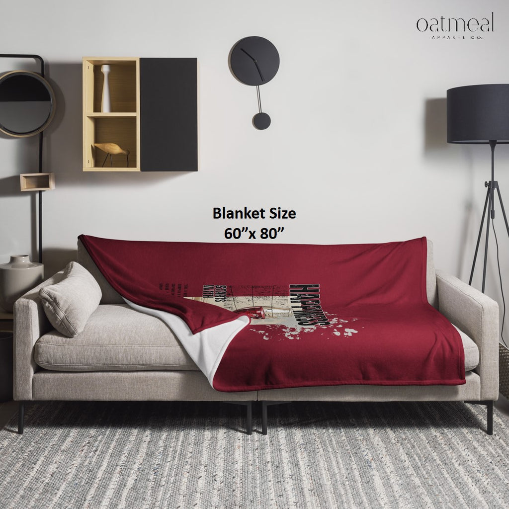 Red blanket draped over a gray sofa in a modern living room with 'oatmeal' branding at Oatmeal Apparel Co.