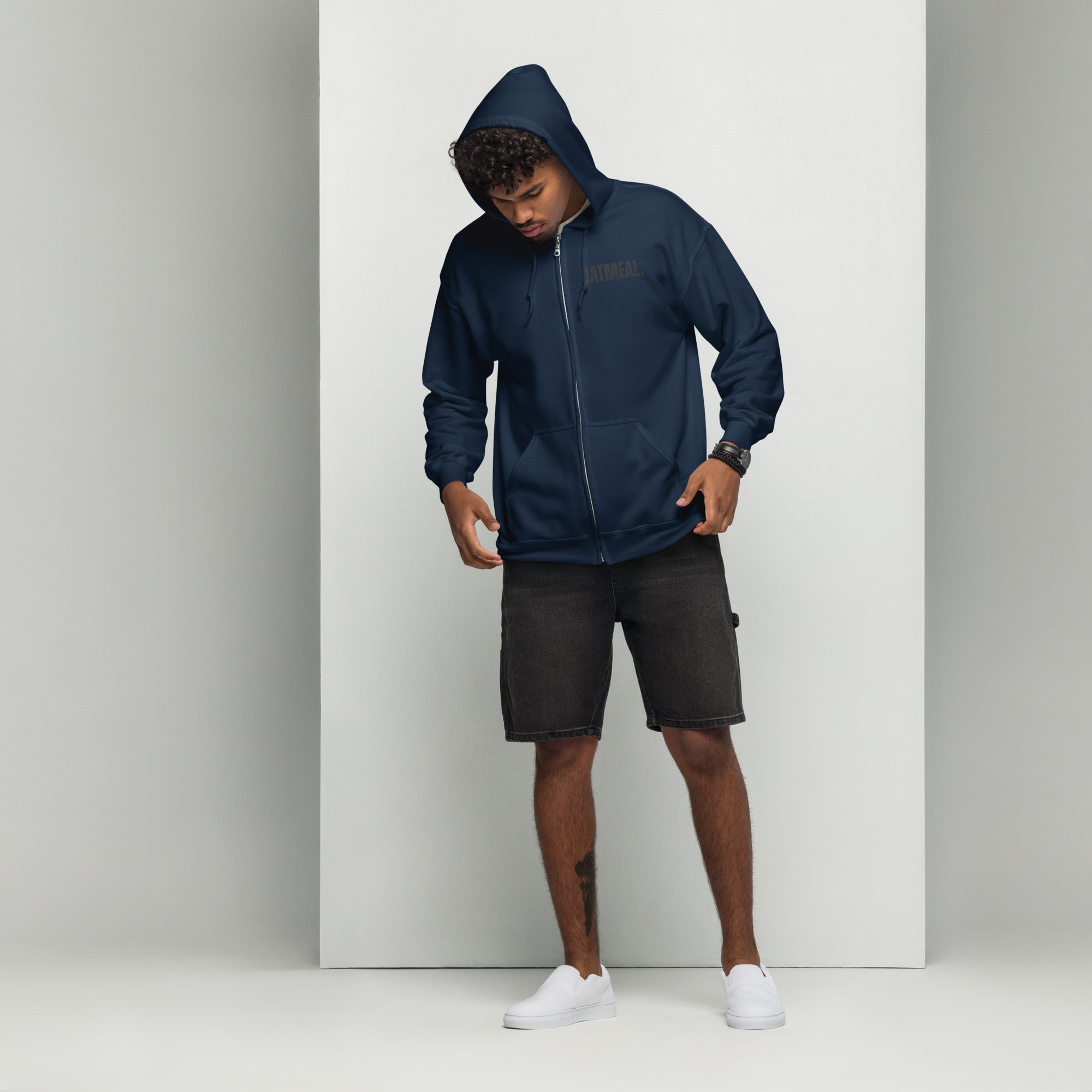 Person wearing a blue jacket and black shorts on a white background at Oatmeal Apparel Co.