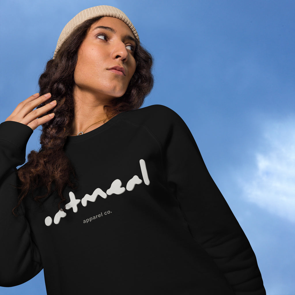 Person wearing a black sweatshirt with 'oatmeal apparel co.' text against a blue sky.