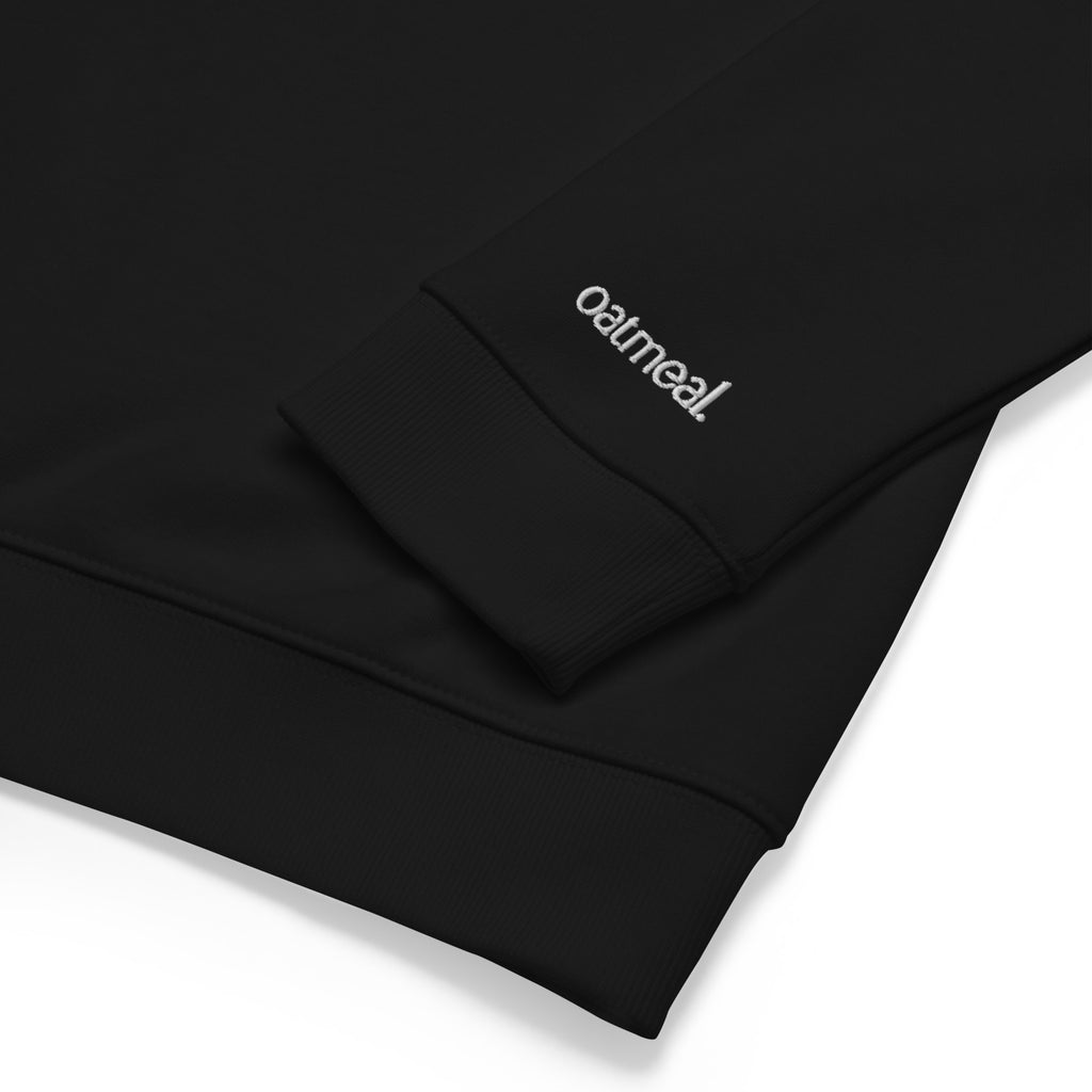 Black fabric with embroidered 'oatmeal' logo on a white background at Oatmeal Apparel Co.