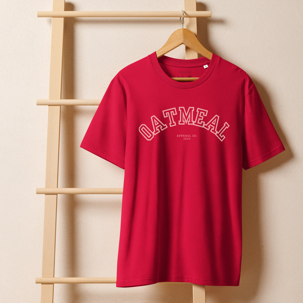 Red t-shirt with 'OATMEAL' branding on a wooden hanger against a beige wall at Oatmeal Apparel Co., Sports Edition Design.