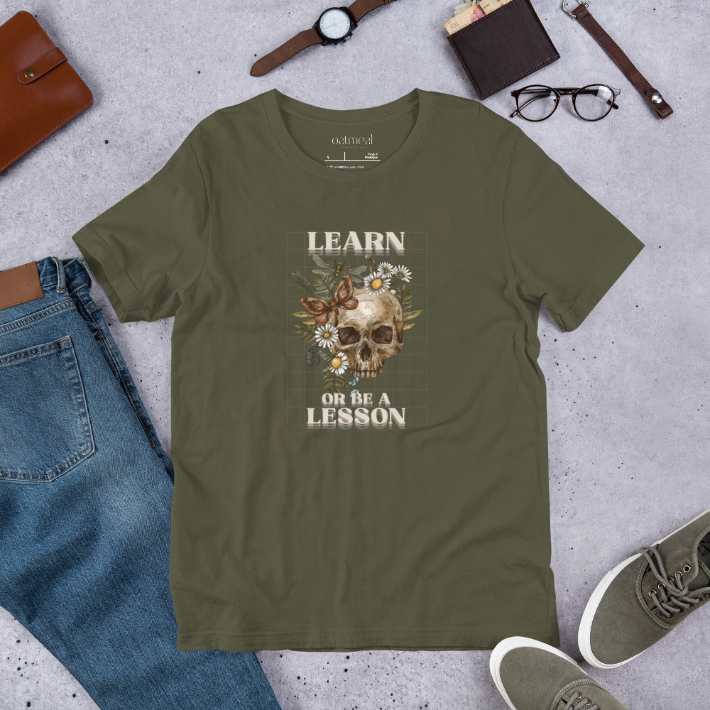 Green t-shirt with 'LEARN OR BE A LESSON' text with jeans and accessories at Oatmeal Apparel Co.