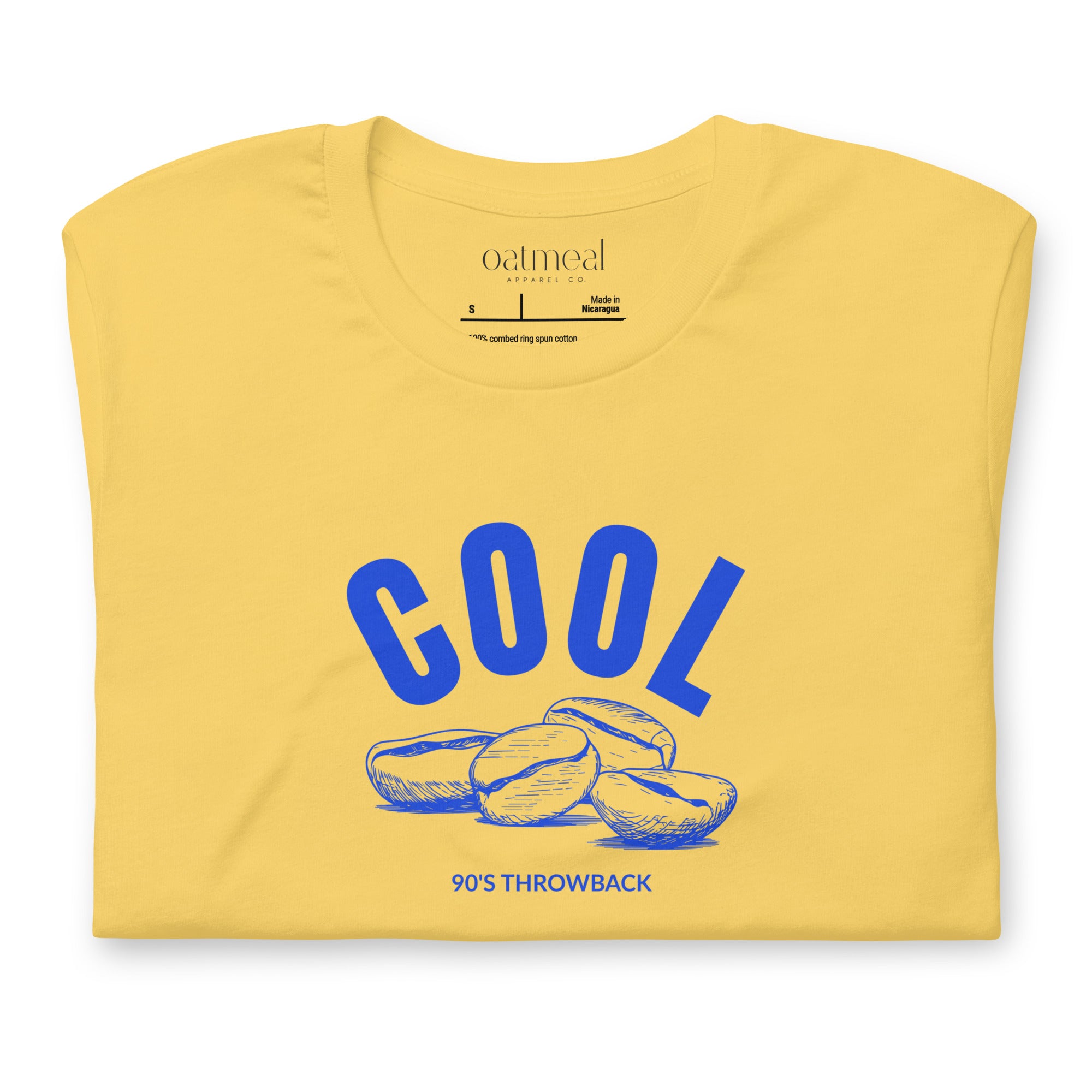 Yellow t-shirt with blue 'COOL Beans' graphic and 'Oatmeal' branding on a white background at Oatmeal Apparel Co.