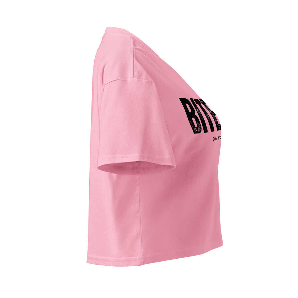 Side view of Pink crop top with black 'BITE ME' text on a white background at Oatmeal Apparel Co.