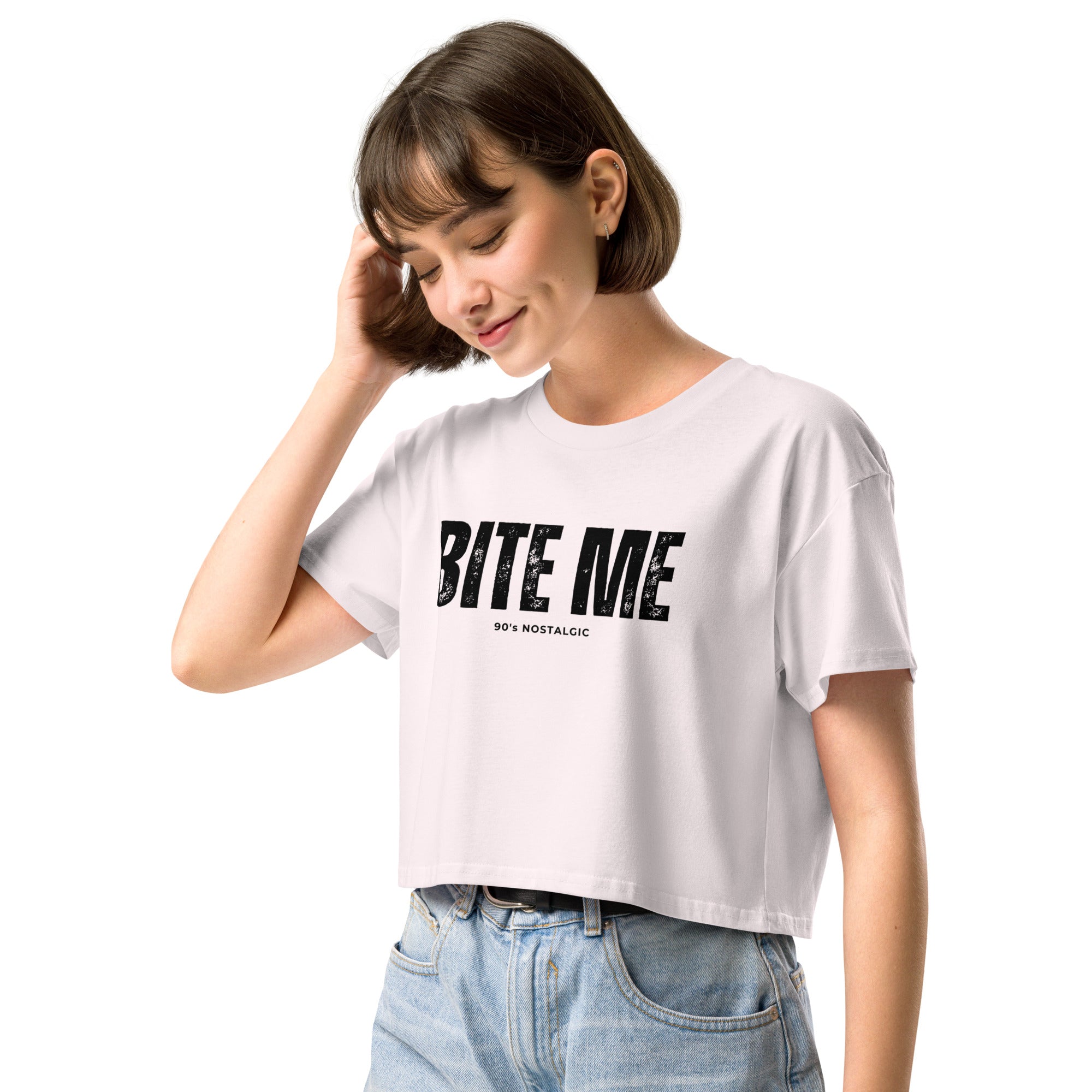 Woman wearing a white crop top with 'BITE ME' text on a white background at Oatmeal Apparel Co.