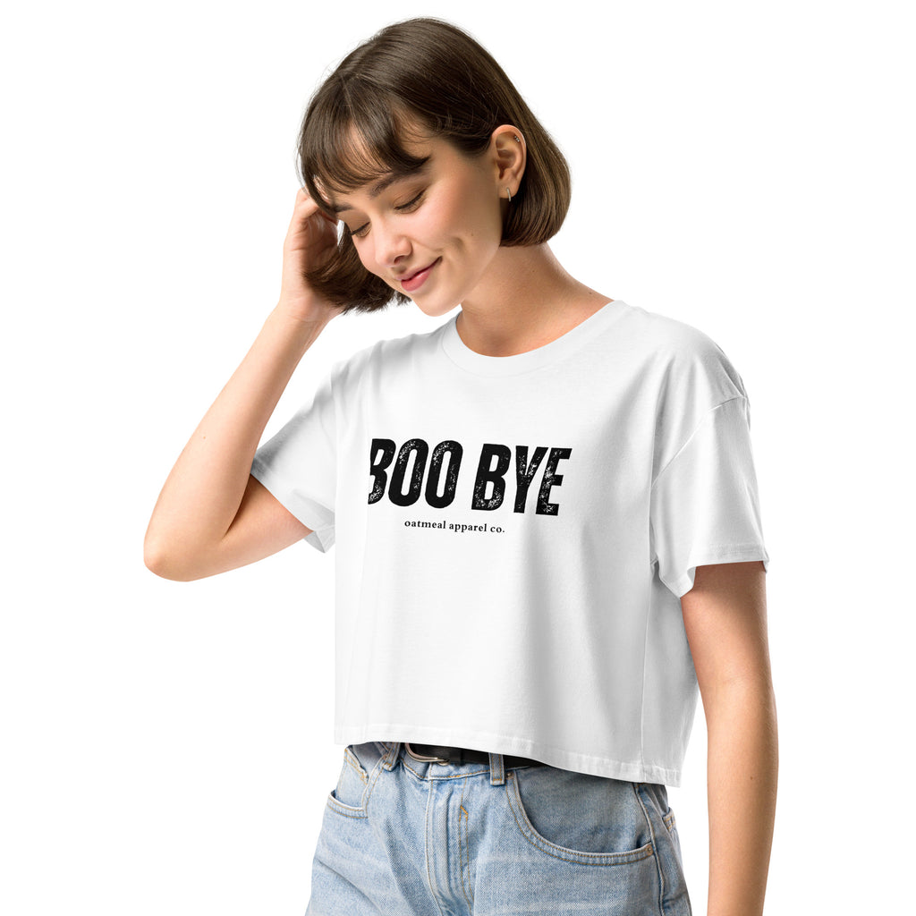 Woman wearing a white crop top with 'BOO BYE' text on a white background at Oatmeal Apparel Co.