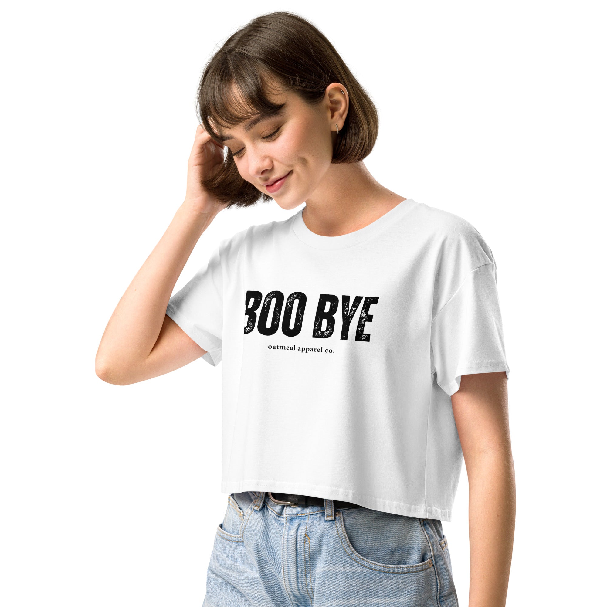 Woman wearing a white crop top with 'BOO BYE' text on a white background at Oatmeal Apparel Co.