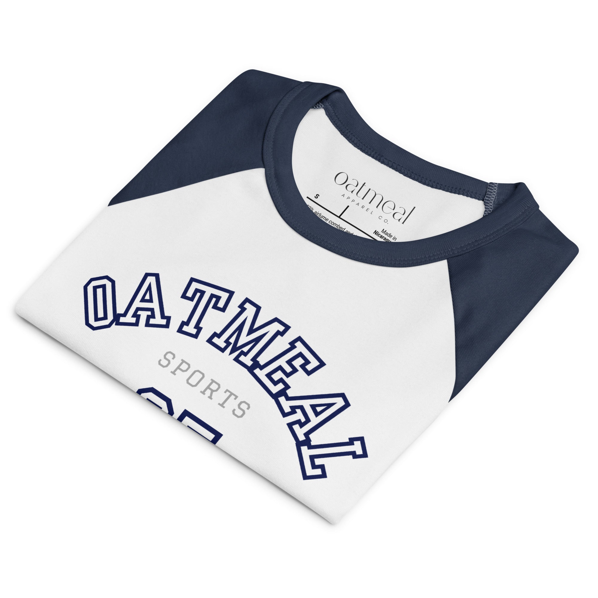 Folded white and navy baseball shirt with 'Oatmeal Sports' text on a white background at Oatmeal Apparel Co.