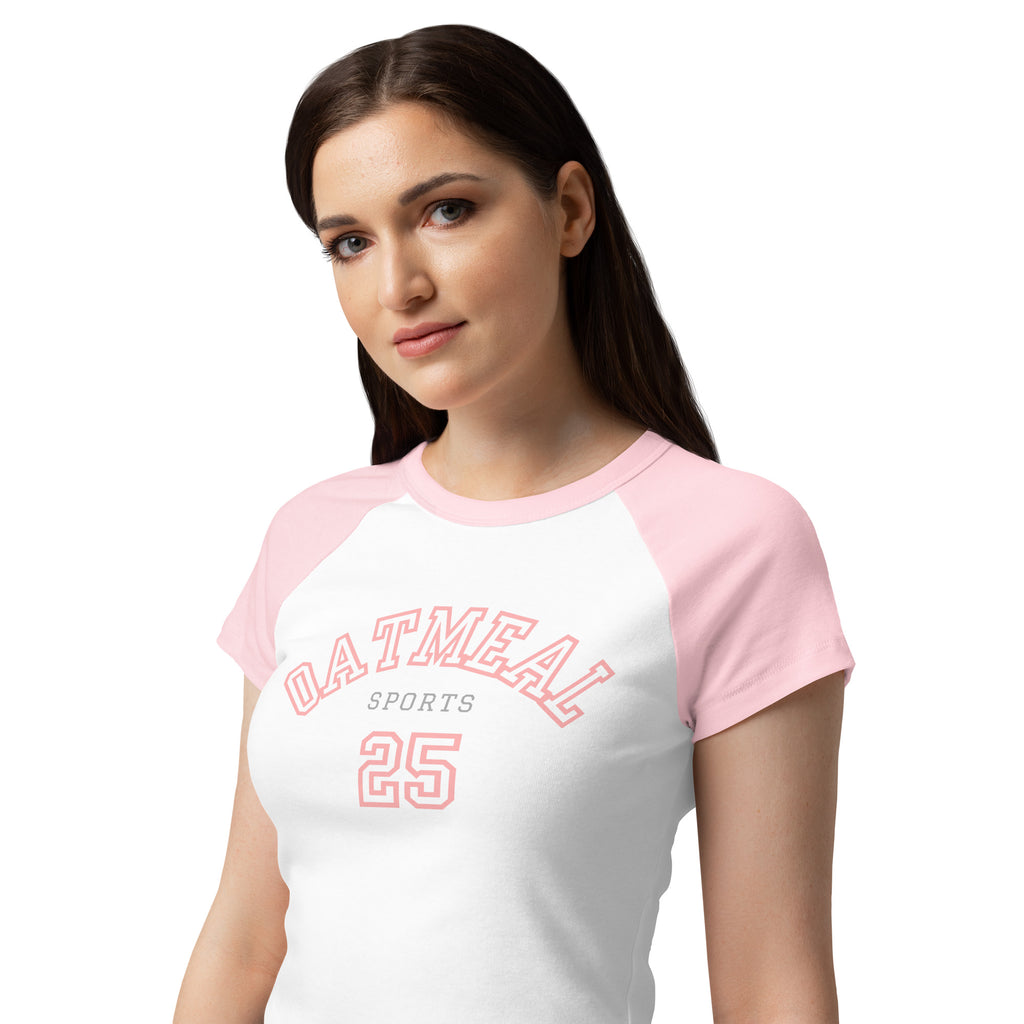 Woman wearing a white and pink baseball shirt with 'Oatmeal Sports 25' text and graphics at Oatmeal Apparel Co.