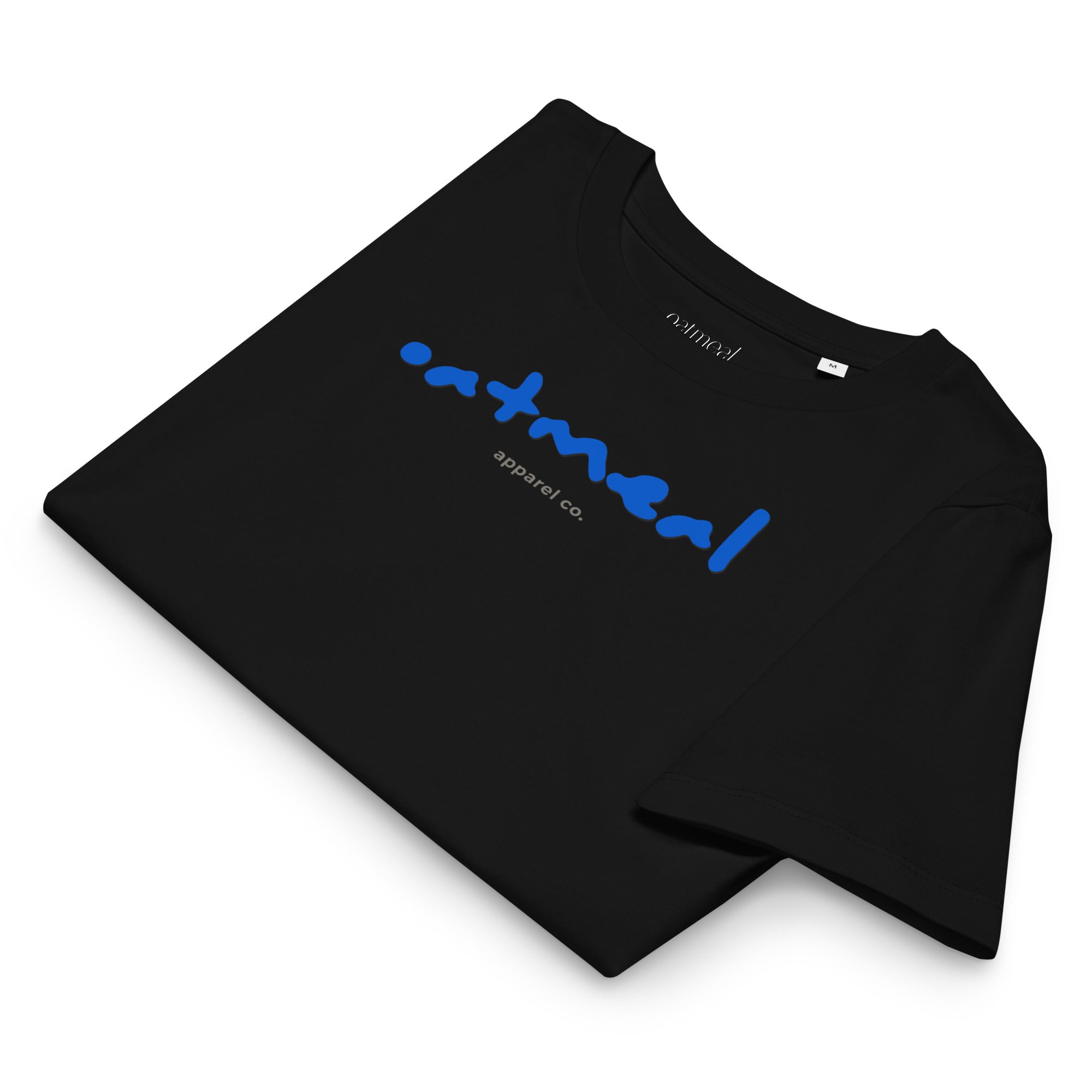 Black folded t-shirt with blue 'oatmeal apparel co.' text on a white background.