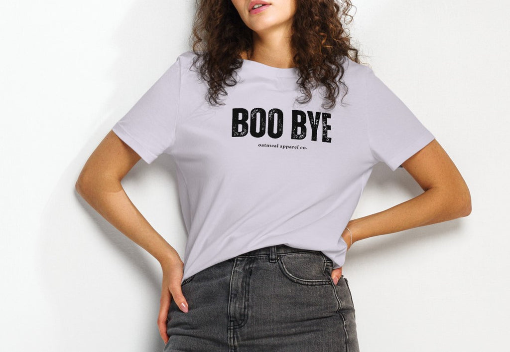 Person wearing a white t-shirt with 'BOO BYE' text on a plain background at Oatmeal Apparel Co.
